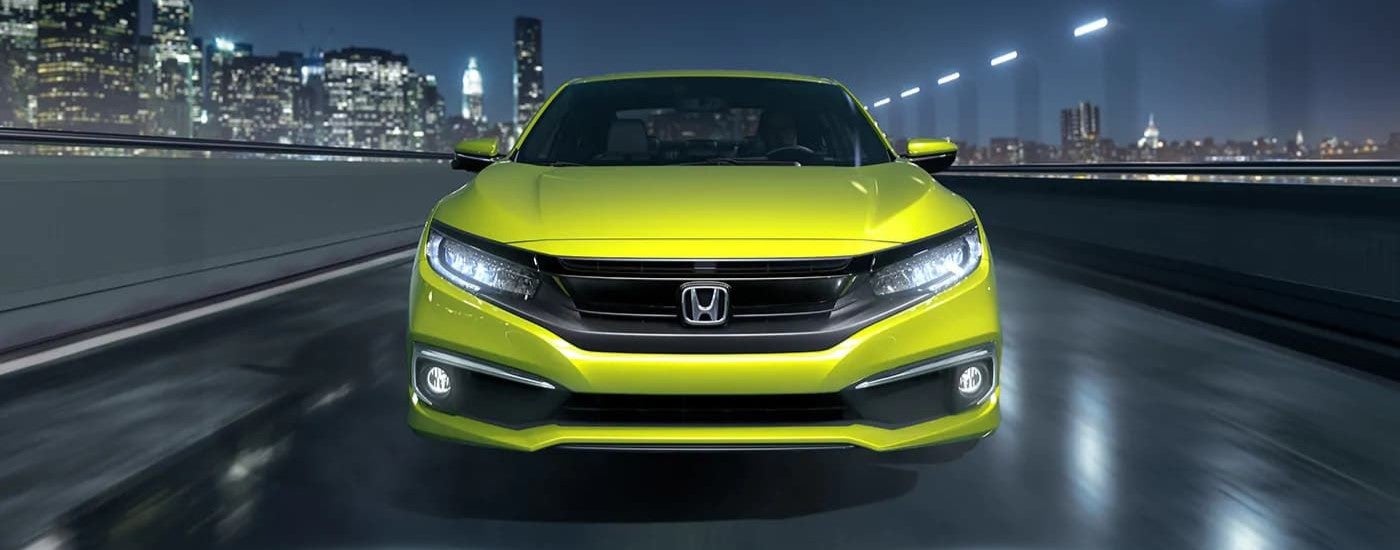 Yellow 2019 Honda Civic Touring driving down a bridge.