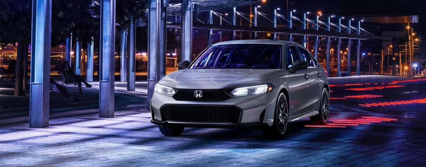 Grey 2026 Honda Civic driving under an awning