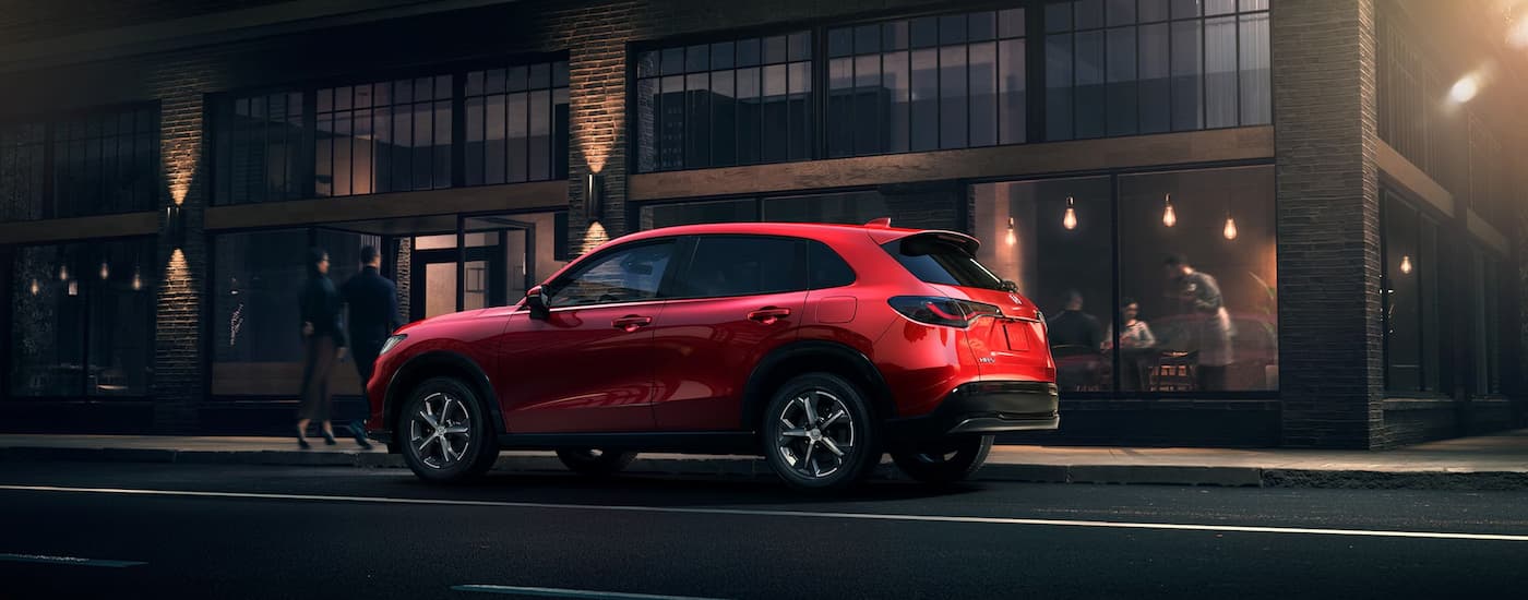 Rear of a red 2026 Honda HR-V parked by a curb.