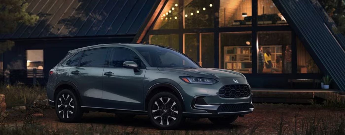 Green 2026 Honda HR-V EX-L parked in front of a cabin.