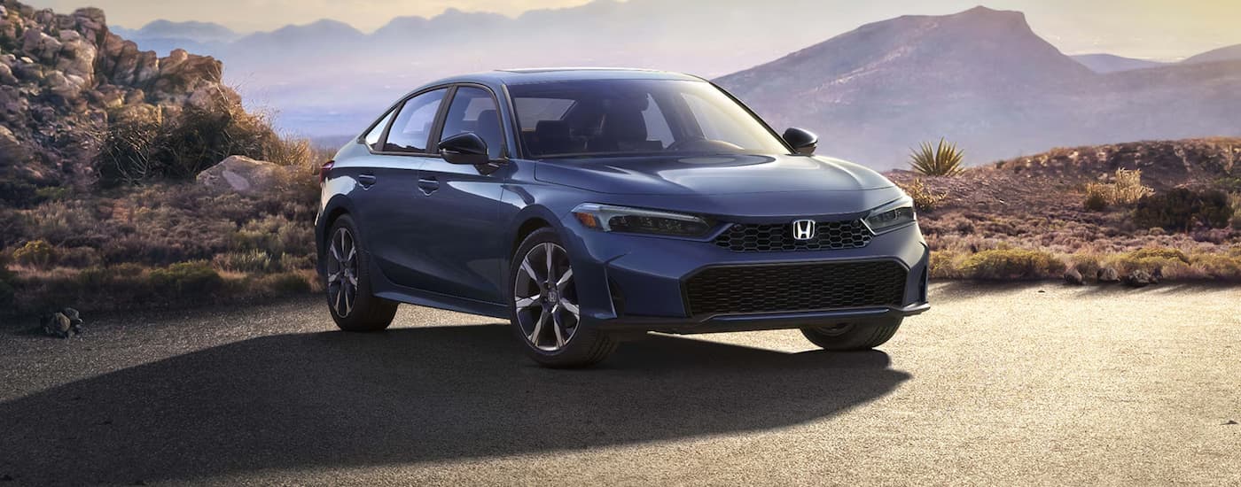 Blue 2026 Honda Civic Sport Touring parked on pavement.