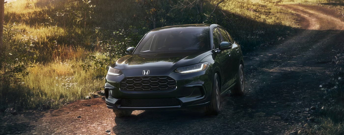 Black 2026 Honda HR-V driving off-road down a hill.