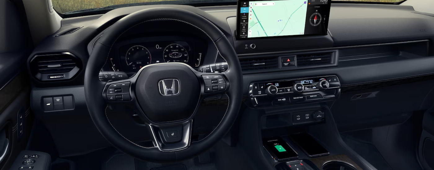 Wheel and dashboard in the interior of a 2026 Honda Pilot.