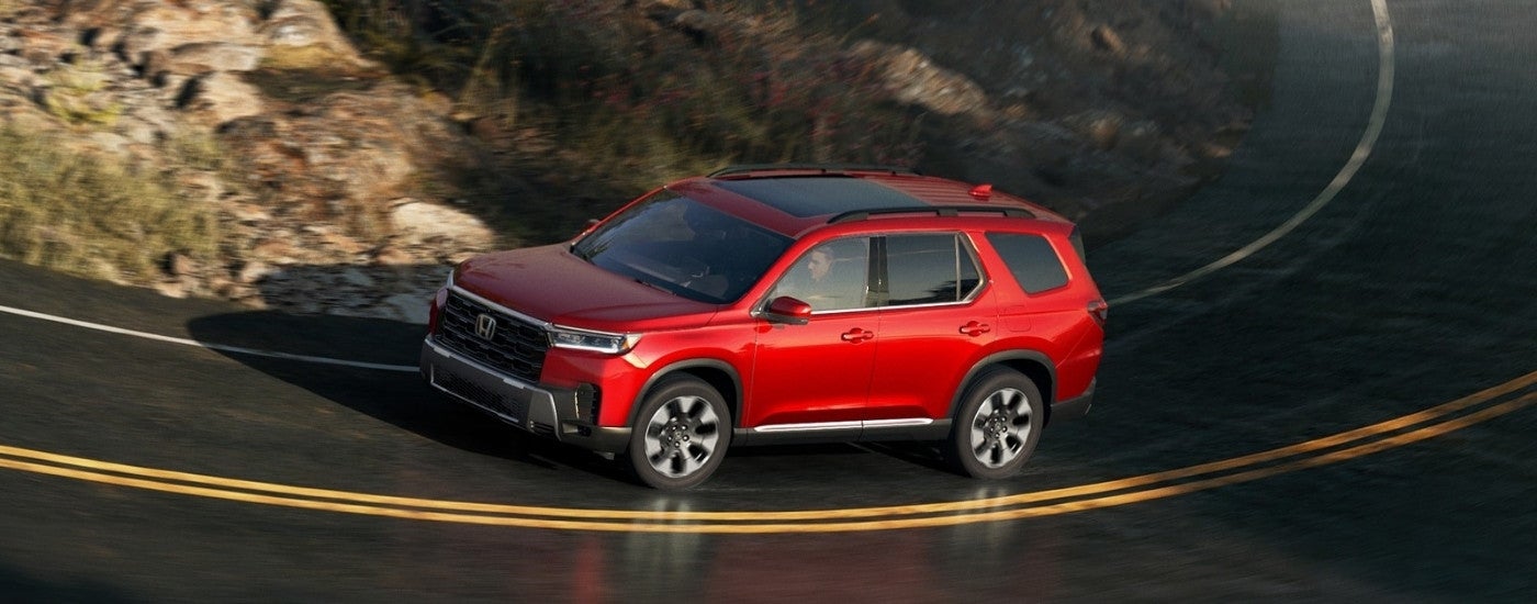 A red 2026 Honda Pilot from the side.