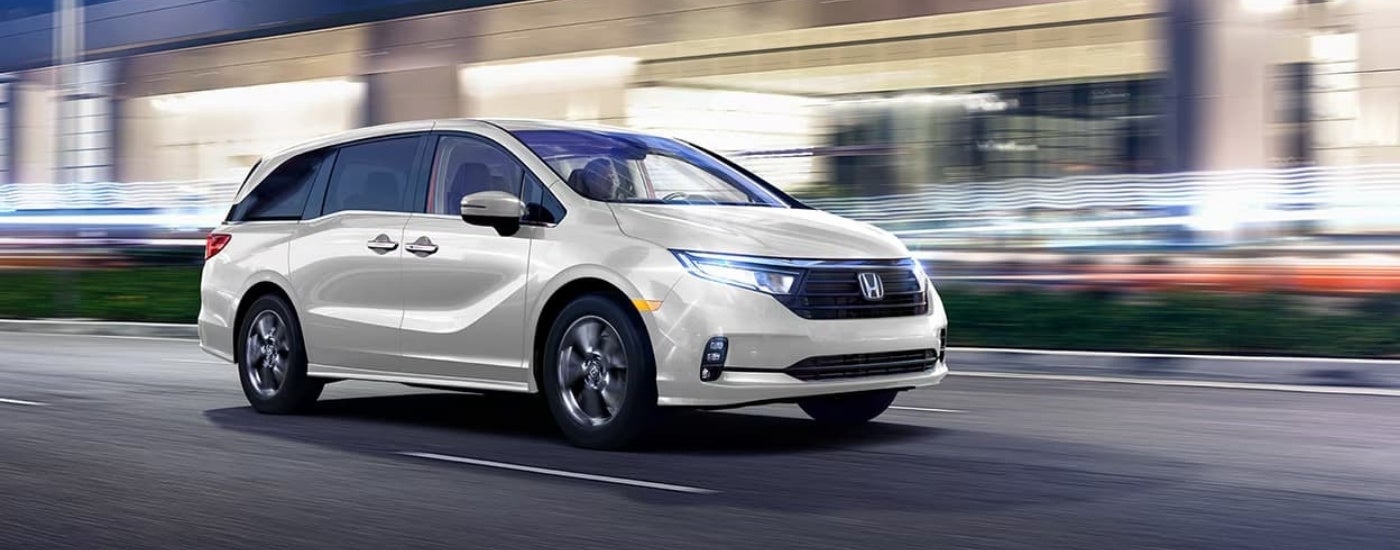 A white 2023 Honda Odyssey driving at night.