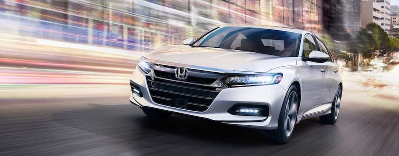A white 2020 Honda Accord driving in a city.