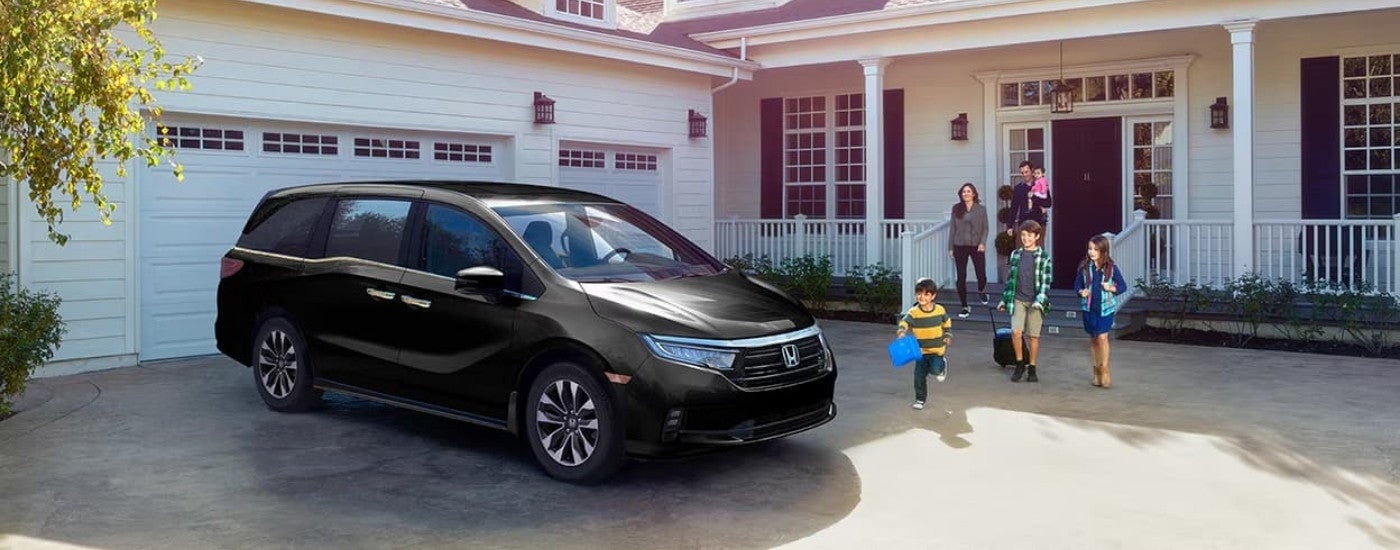 A black 2025 Honda Odyssey parked in a driveway from a dealer near Dothan